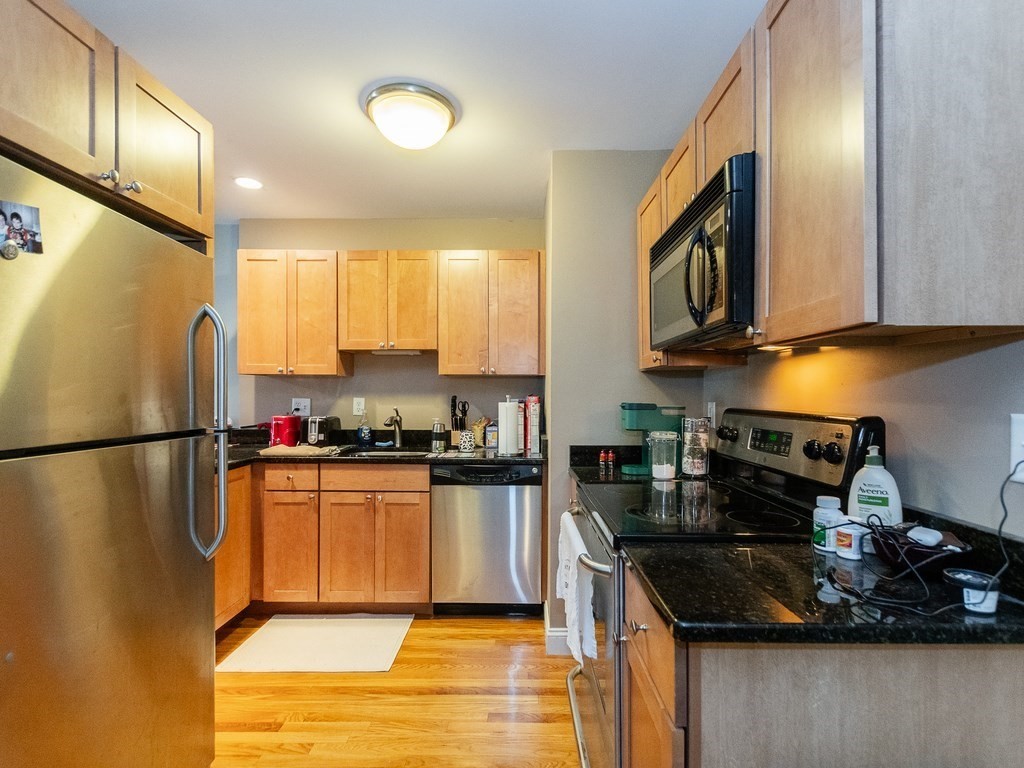 48 Coffey Street, Unit 5B Boston, MA 02122 - Photo 9 of 31 a kitchen with stainless steel appliances granite countertop a refrigerator stove sink and cabinets