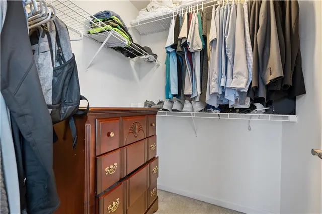 a view of walk in closet with clothes and shoes