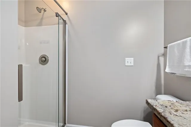 a bathroom with a granite countertop sink toilet and shower