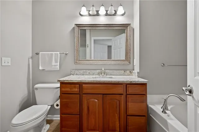 a bathroom with a sink vanity mirror and toilet