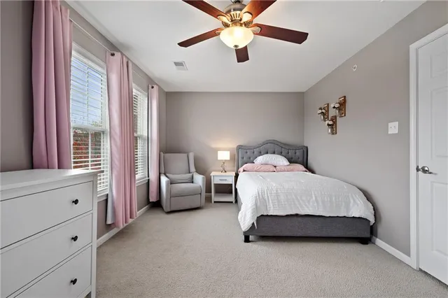 a spacious bedroom with a bed and a chandelier
