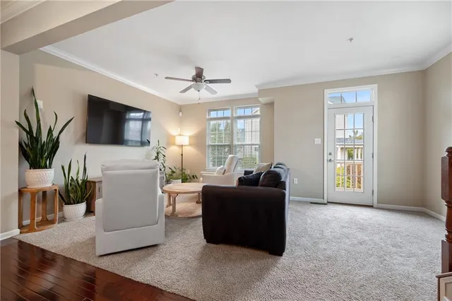 a living room with furniture a flat screen tv and a window