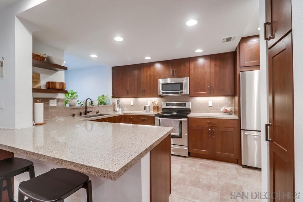 a kitchen with kitchen island a counter top space cabinets and stainless steel appliances