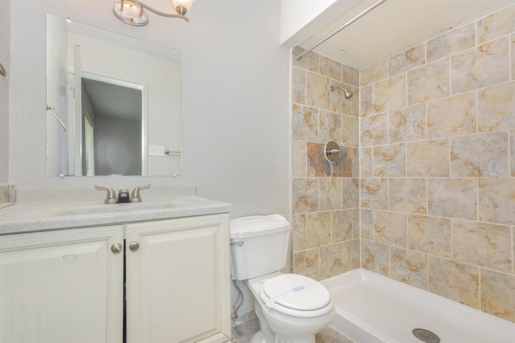 5549 Ragan Drive The Colony, TX 75056 - Photo 16 of 22 a bathroom with a granite countertop sink a toilet and shower
