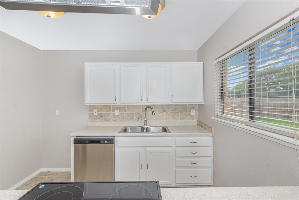 5549 Ragan Drive The Colony, TX 75056 - Photo 6 of 22 a kitchen with cabinets appliances a sink and a window