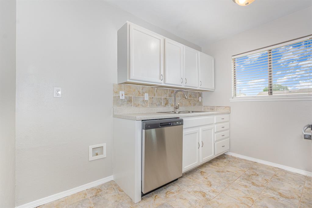 5549 Ragan Drive The Colony, TX 75056 - Photo 7 of 22 a kitchen with white cabinets and white appliances
