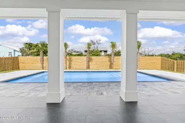 a kitchen with stainless steel appliances kitchen island granite countertop a refrigerator a sink dishwasher and white cabinets with wooden floor