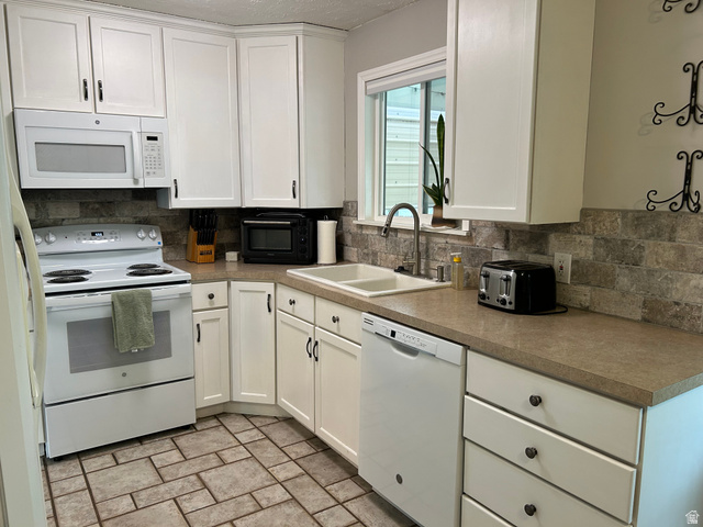 7659 State Street Midvale, UT 84047 - Photo 6 of 33 Kitchen with white cabinetry, white appliances, and tasteful backsplash