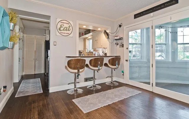 a view of a hallway with wooden floor and furniture