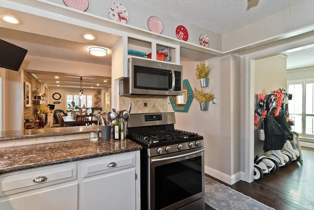 a kitchen with granite countertop a stove and a sink