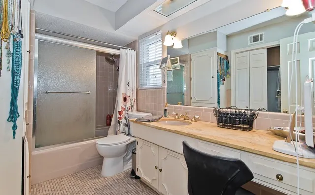 a bathroom with a double vanity sink toilet mirror and bathtub