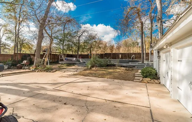 a front view of a house with a yard fountain and a tree