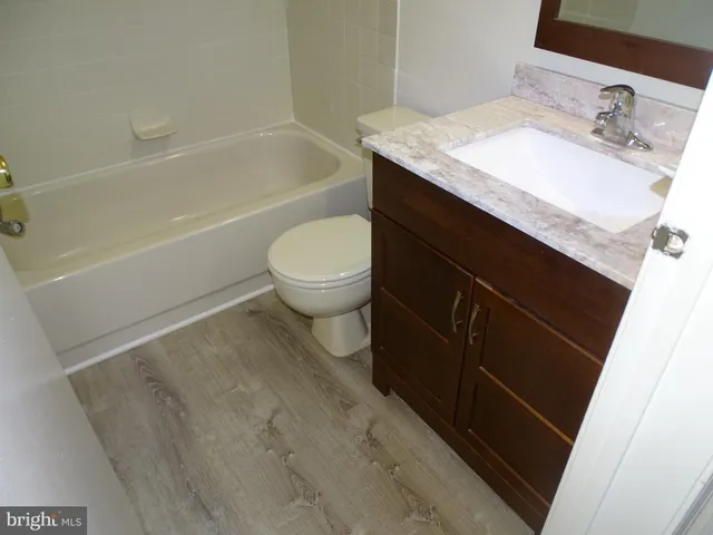 a bathroom with a granite countertop sink toilet and bathtub