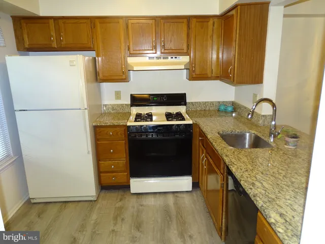a kitchen with a stove top oven and refrigerator