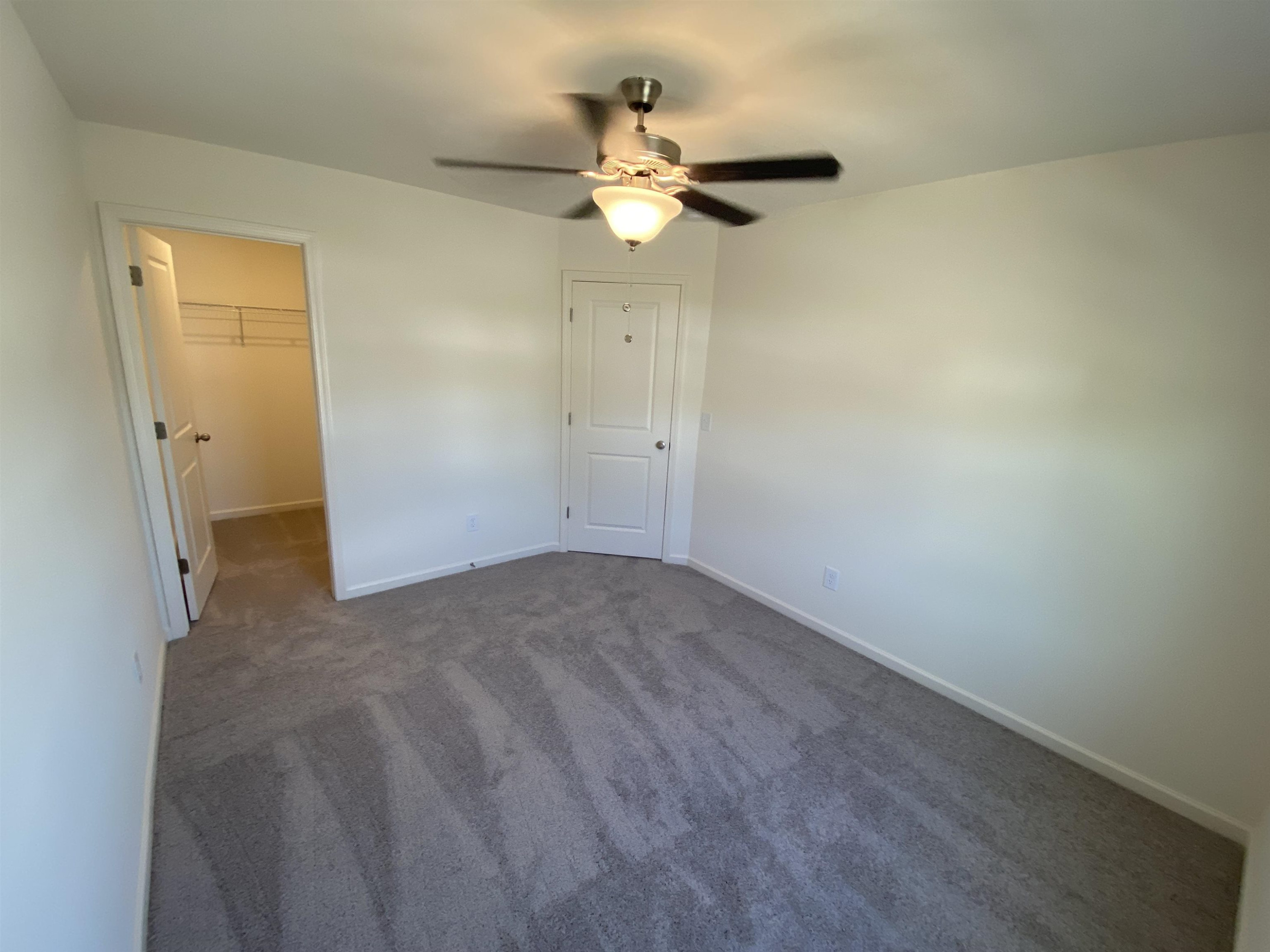3403 A Walker Wilson, NC 27893 - Photo 19 of 23 an empty room with a chandelier fan and windows