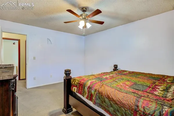 a bedroom with a bed and a ceiling fan