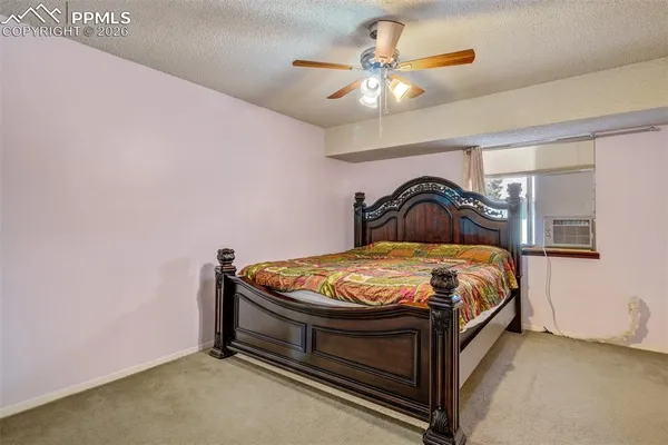 a bedroom with a bed and a ceiling fan