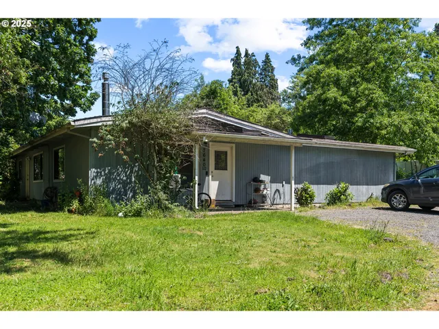 a view of a house with a yard and sitting area