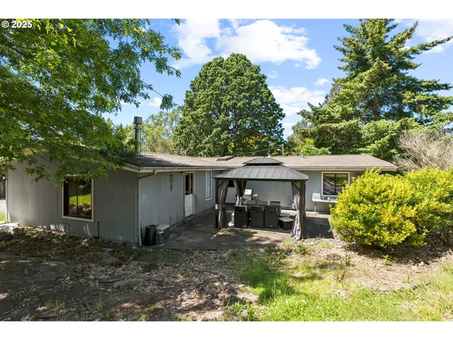 a view of a house with backyard and sitting area