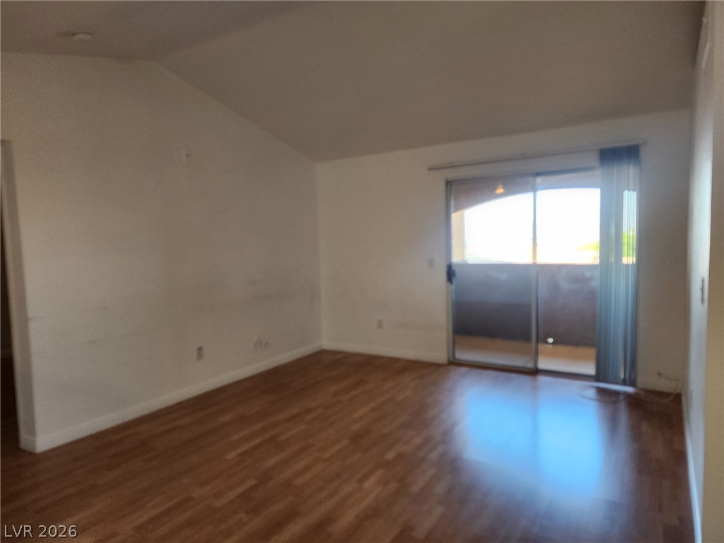 231 West Horizon Ridge Parkway, Unit 1127 Henderson, NV 89012 - Photo 26 of 39 A living space with wood flooring and vaulted ceilings opens to a private balcony.