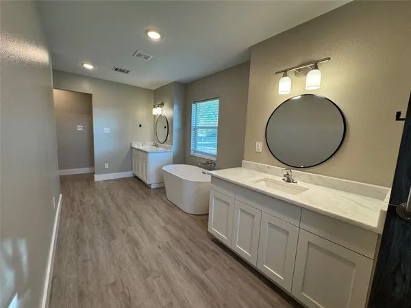 a bathroom with a double vanity sink mirror and toilet