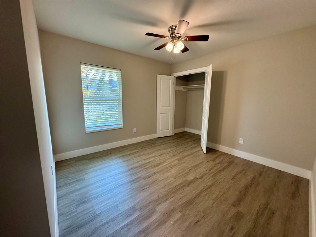813 Central Avenue Elgin, TX 78621 - Photo 21 of 26 an empty room with wooden floor and windows