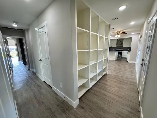 a view of hallway with wooden floor and closet