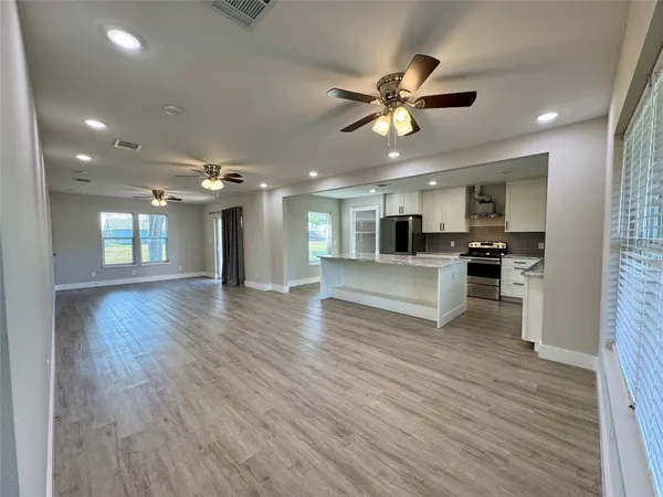 a view of kitchen with cabinets microwave and stove