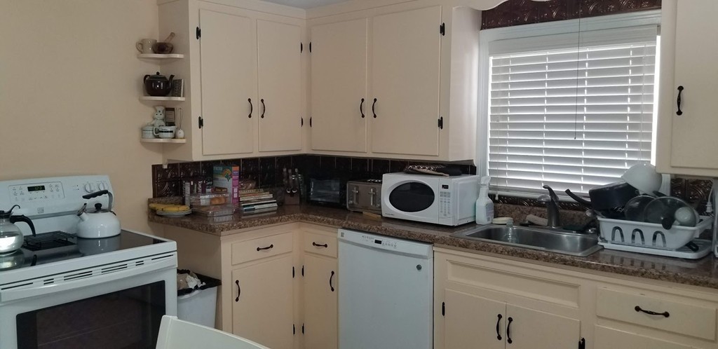 43 Sargon Street Springfield, MA 01104 - Photo 16 of 25 a kitchen with a stove and white cabinets