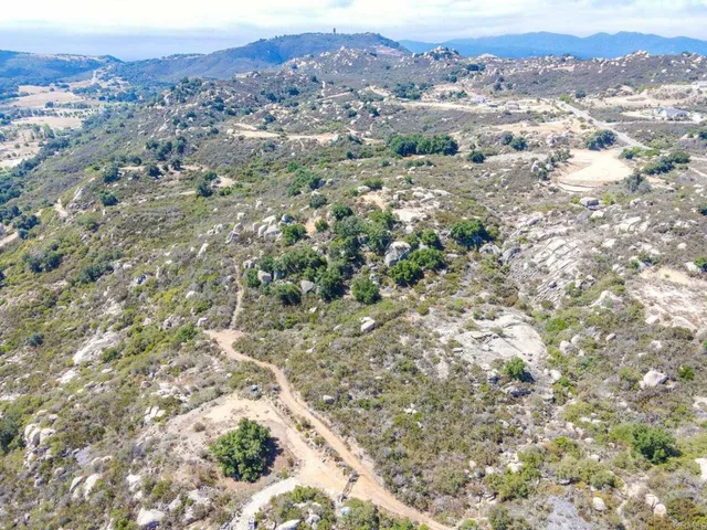 an aerial view of residential houses with outdoor space and trees