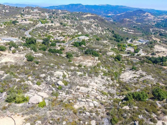 an aerial view of residential house with yard and mountain view in back