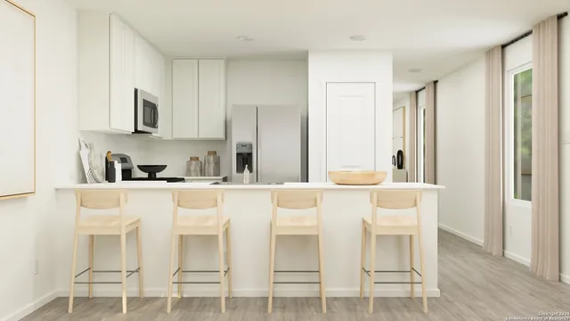 a white kitchen with stainless steel appliances granite countertop a stove a sink refrigerator and white cabinets with wooden floor