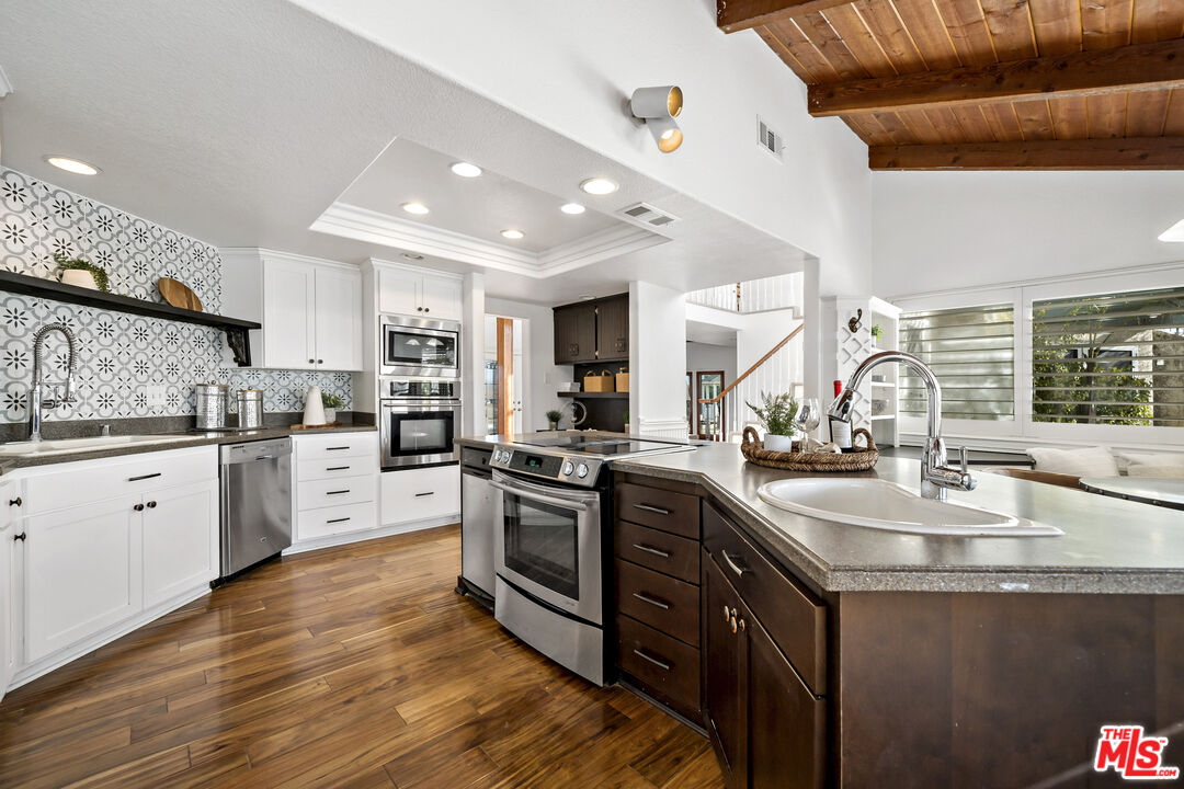 38675 Green Meadow Road Temecula, CA 92592 - Photo 47 of 74 a large kitchen with stainless steel appliances granite countertop a lot of counter space and wooden floors