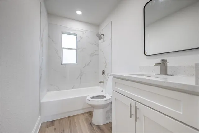 a bathroom with a bathtub shower sink vanity and toilet