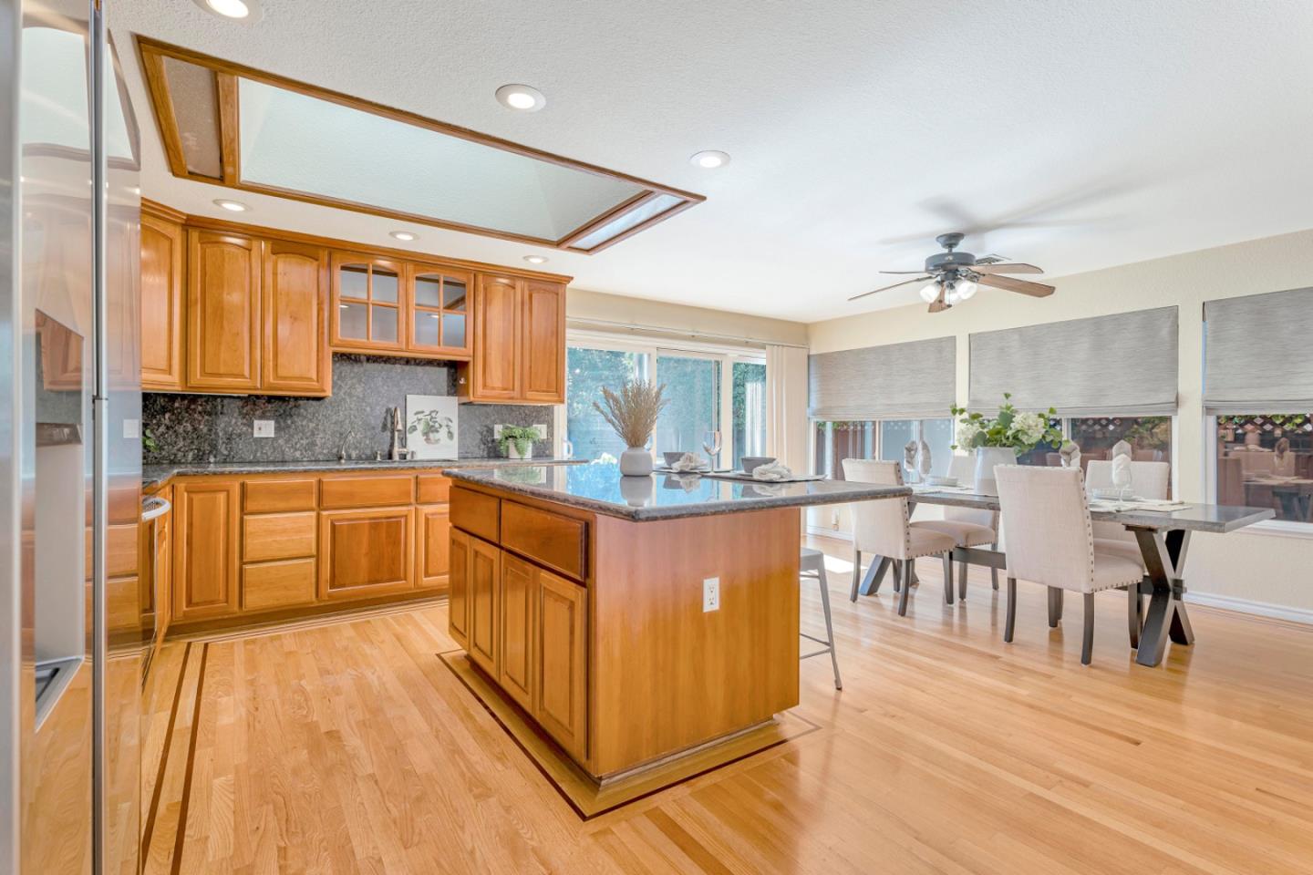4692 Mia Circle San Jose, CA 95136 - Photo 15 of 42 a kitchen with stainless steel appliances granite countertop a refrigerator a sink dishwasher a dining table and chairs with wooden floor