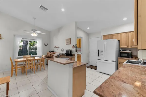 a kitchen with white cabinets and refrigerator