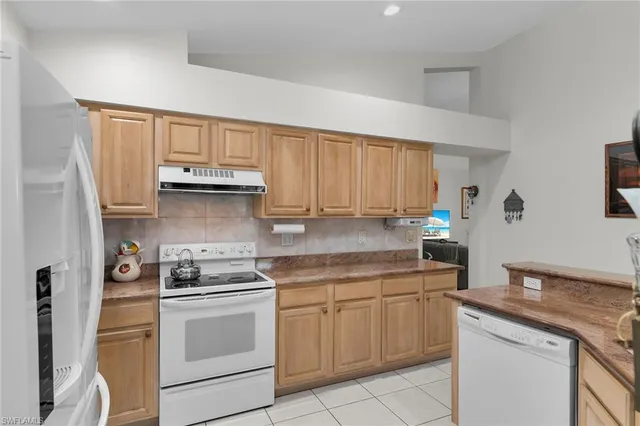 a kitchen with white cabinets and appliances