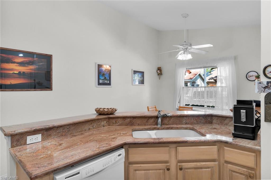 443 Dundee Court Naples, FL 34104 - Photo 25 of 39 a kitchen with a sink and a stove with wooden floor