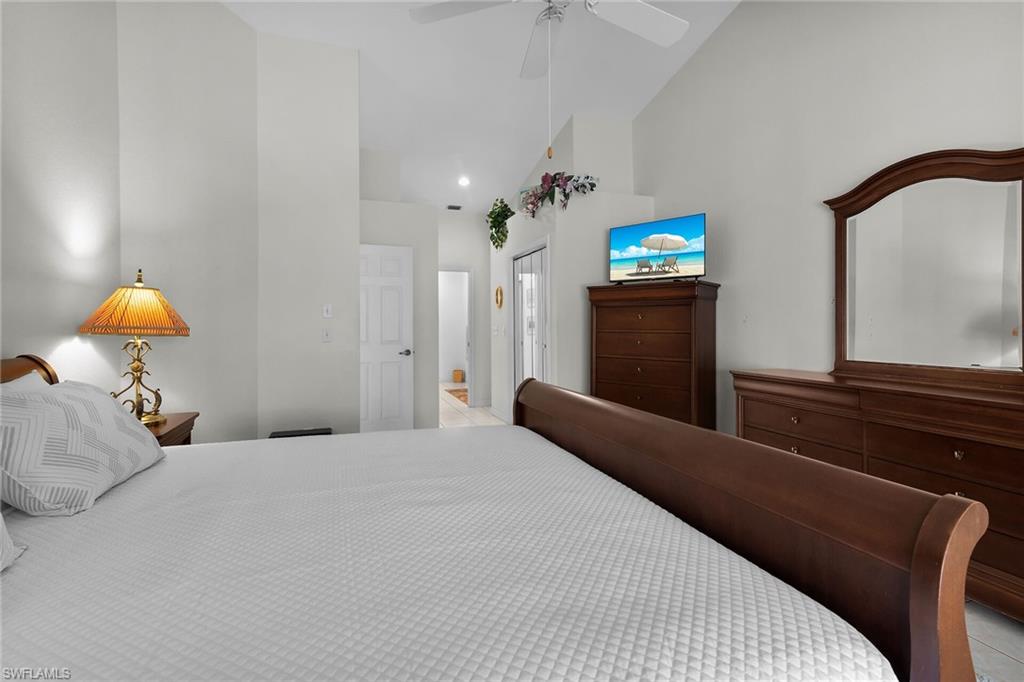 443 Dundee Court Naples, FL 34104 - Photo 27 of 39 a bedroom with a bed and a lamp on dresser