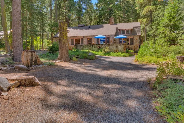 a front view of a house with yard and trees