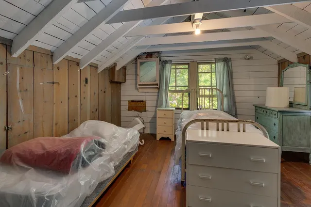a bedroom with a bed mirror and window