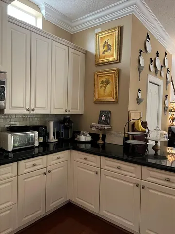 a kitchen with stainless steel appliances granite countertop white cabinets sink and granite countertops