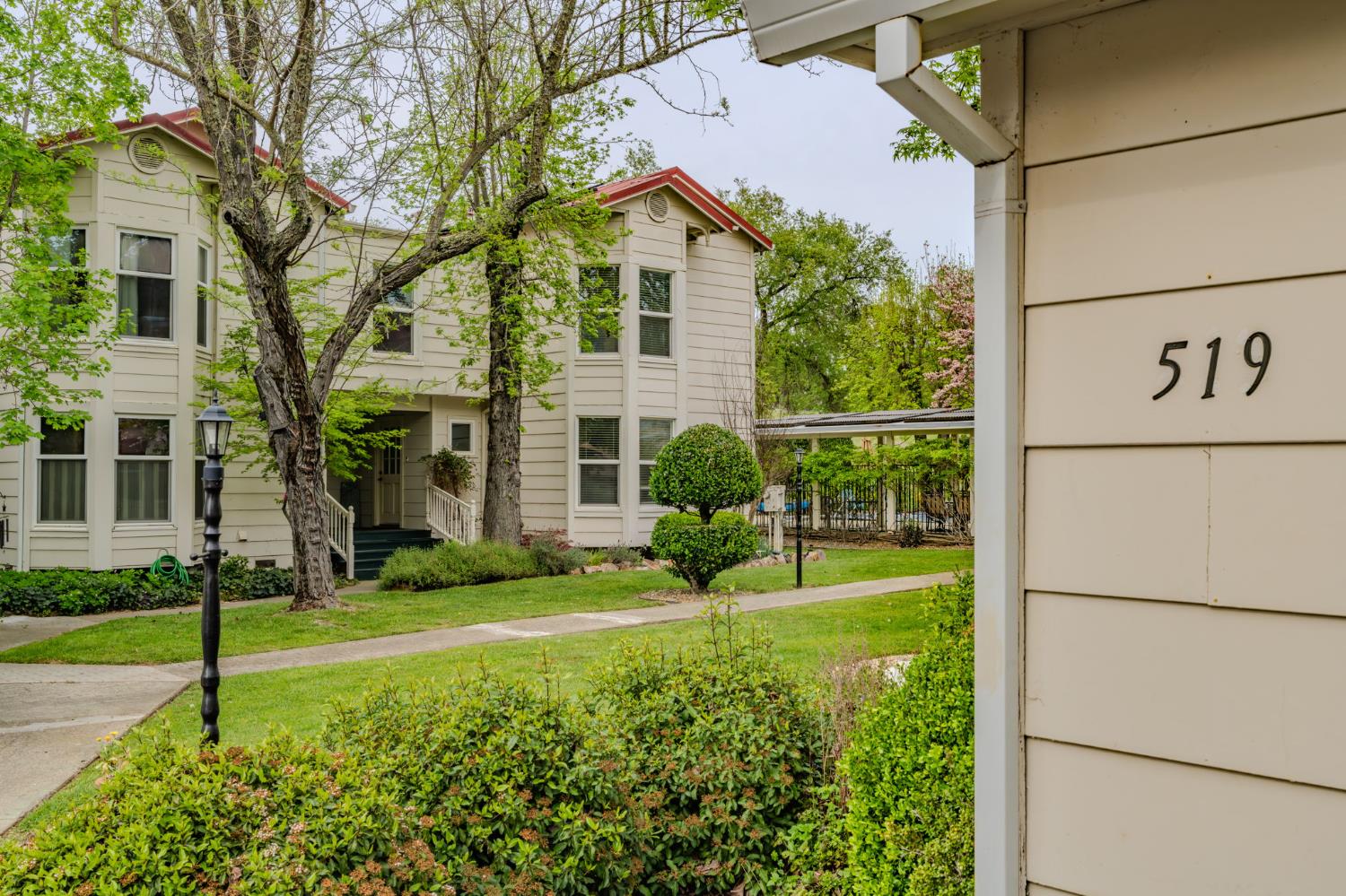 a view of a house with a big yard and potted plants