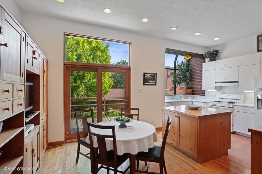 1274 West Lexington Street Chicago, IL 60607 - Photo 7 of 32 a kitchen with stainless steel appliances granite countertop a stove a refrigerator a kitchen island a table and chairs in it