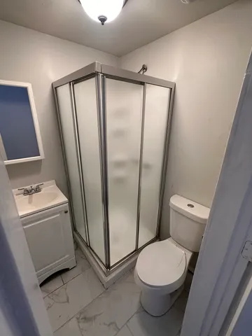 a bathroom with a granite countertop toilet and a shower