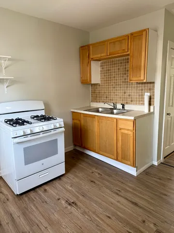a kitchen with stainless steel appliances a stove and wooden floor