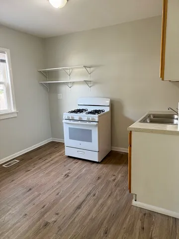 a kitchen with wooden floor and a stove top oven