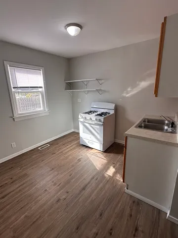a kitchen with wooden floors and appliances