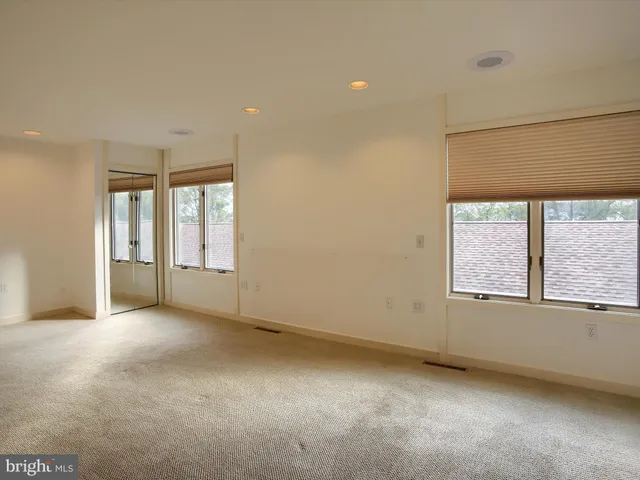 an empty room with windows and closet