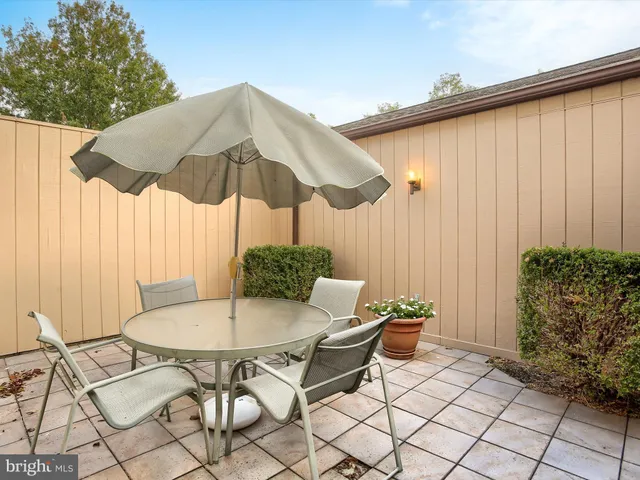 a outdoor seating area with furniture and umbrella